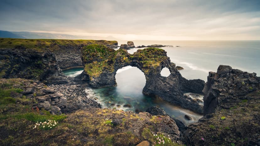 Atmospheric wide-angle view of Gatklettur arch rock formation, Arnarstapi, Snæfellsnes peninsula, Iceland 2021