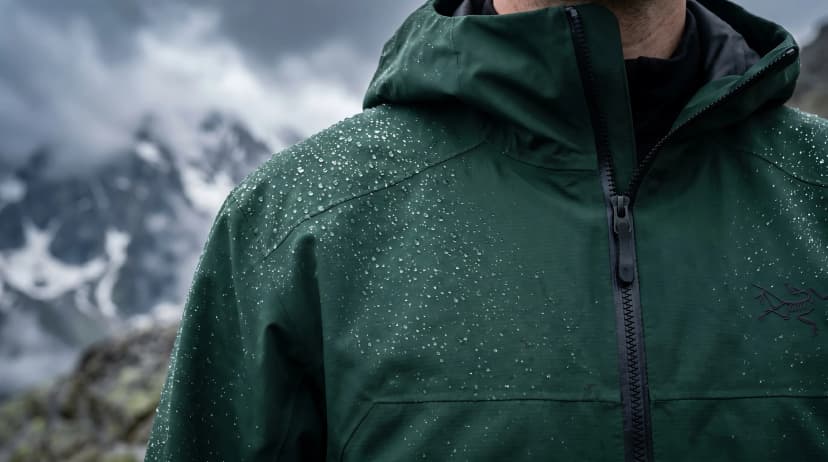 Waterproof Green Outdoor Rain Jacket with Water Droplets in Mountains Vector