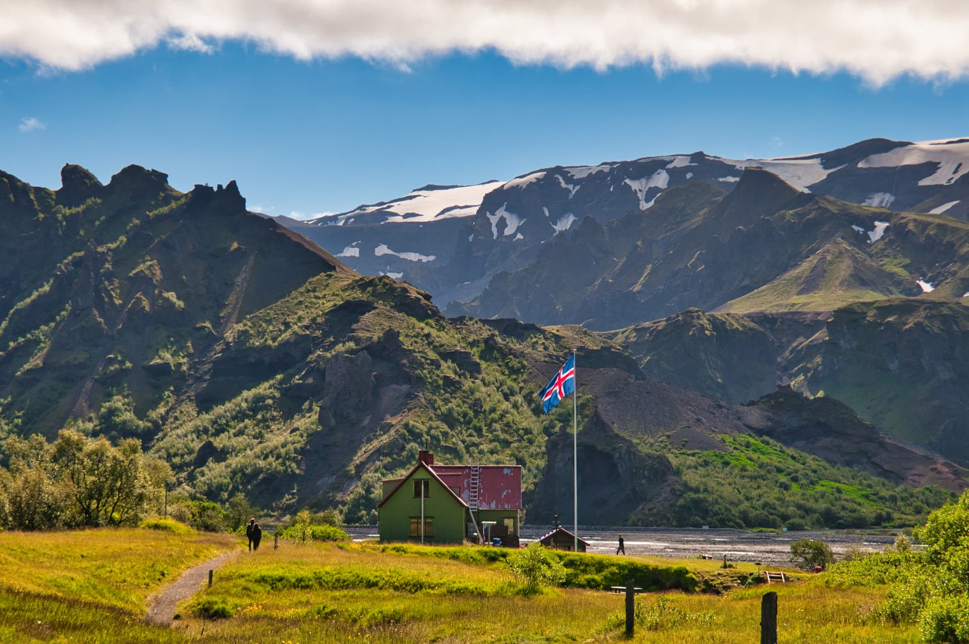 Green hut with Icelandic flag near mountains with snow, Thorsmork.